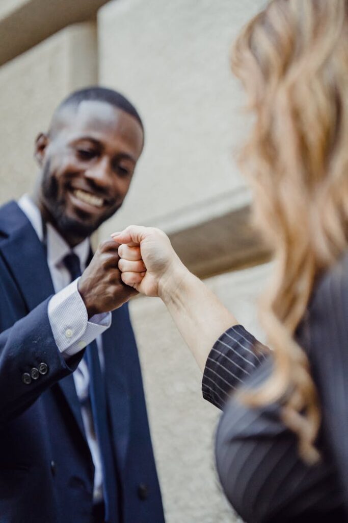 Two business professionals fist bumping in a sign of teamwork and success.